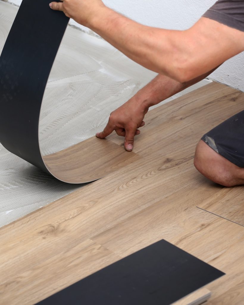 Worker installing new vinyl tile floor